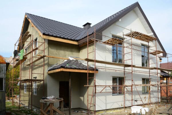 New modern house building home. Roof construction. Metal chimney. Insulated and plastered facade. Metal House roof. Use of scaffolding for the construction of a building.